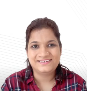 A person with dark hair tied back, wearing a red and navy plaid shirt, smiles at the camera. The background is white with subtle geometric lines, hinting at Renu Thapliyal's involvement in the NEN IGNITE Program.